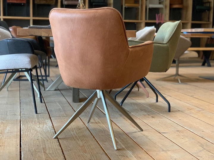 Rückansicht eines modernen Armlehnenstuhls aus hochwertigem Leder in warmem Cognac, drehbar und mit elegantem Metallgestell – zeitloses Design für stilvolle Wohn- und Arbeitsbereiche.
