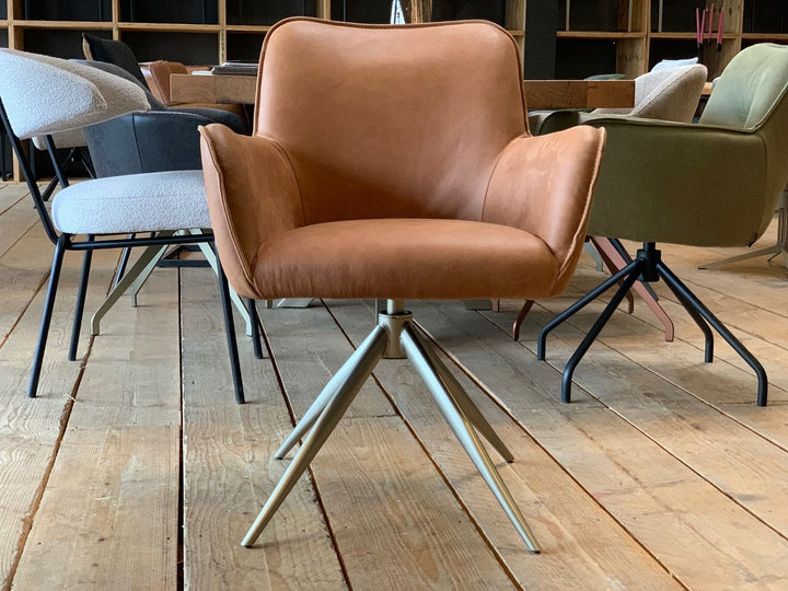 Vorderansicht eines modernen Armlehnenstuhls aus hochwertigem Leder in edlem Cognac, drehbar und mit filigranem Metallgestell – stilvoller Komfort für Esszimmer, Büro oder Konferenzraum.
