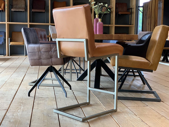 Barhocker Leder in Cognac-Optik mit hoher Rückenlehne und modernem Metallgestell, Rückansicht in stilvollem Essbereich mit Holztisch.