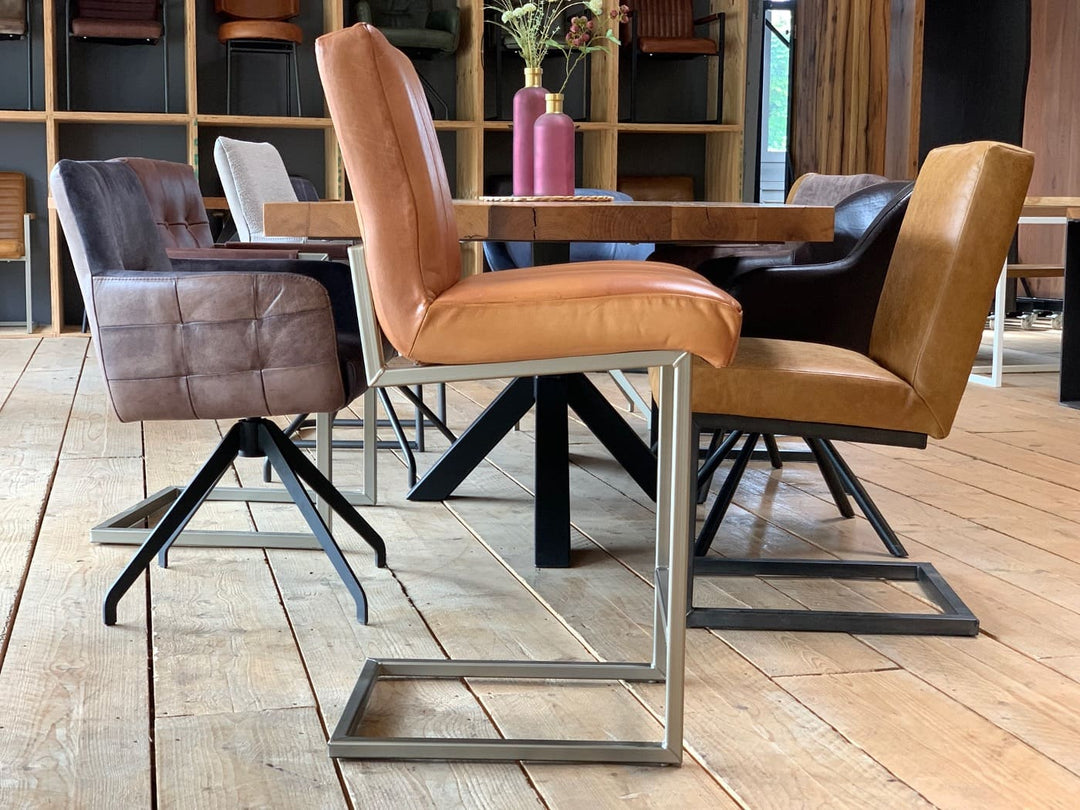 Barhocker Leder in warmem Braunton mit gepolsterter Sitzfläche und modernem Metallgestell, um einen Holztisch in stilvollem Essbereich arrangiert.