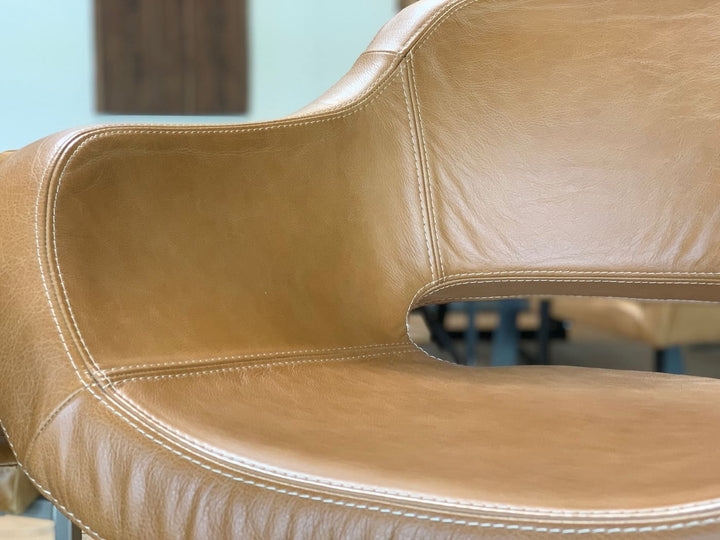 Detailaufnahme eines drehbaren Barhockers aus Echtleder mit ergonomisch geformter Sitzschale, weicher Polsterung und hochwertiger Doppelnaht – stilvoller Thekenstuhl in modernem Design mit hohem Sitzkomfort.