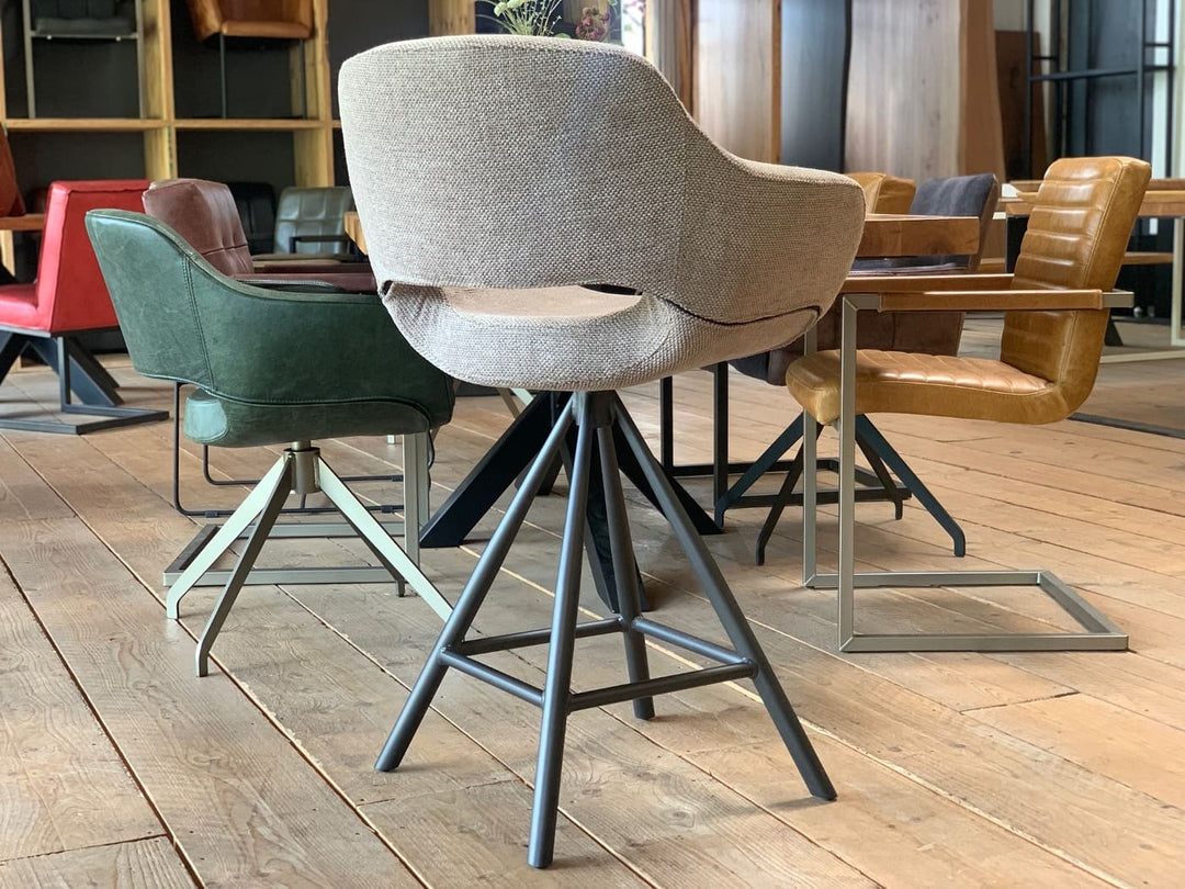Seitenansicht eines drehbaren Barhockers mit hochwertigem Stoffbezug, ergonomisch geformter Sitzschale und stabilem Metallgestell – moderner Thekenstuhl mit hohem Sitzkomfort und elegantem Design.