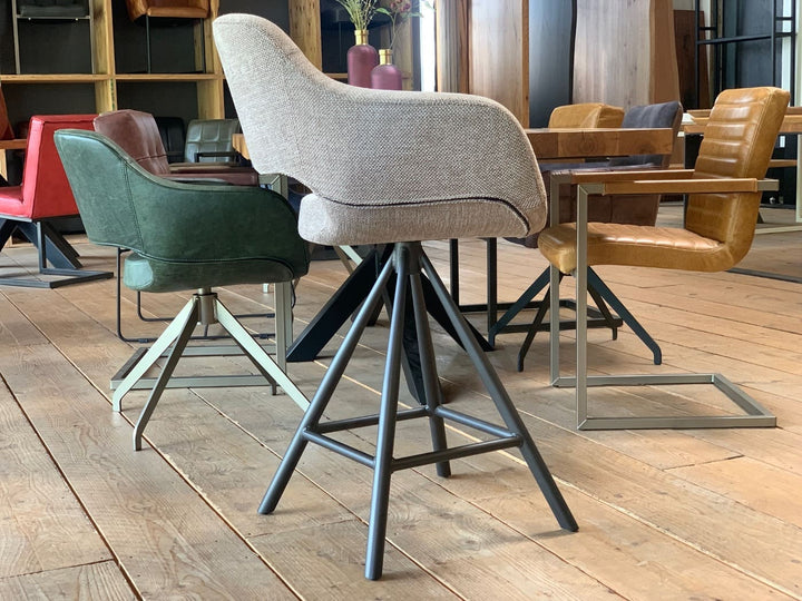 Seitenansicht eines drehbaren Barhockers mit hochwertigem Stoffbezug, ergonomisch geformter Sitzschale und stabilem Metallgestell – moderner Thekenstuhl mit hohem Sitzkomfort und elegantem Design.