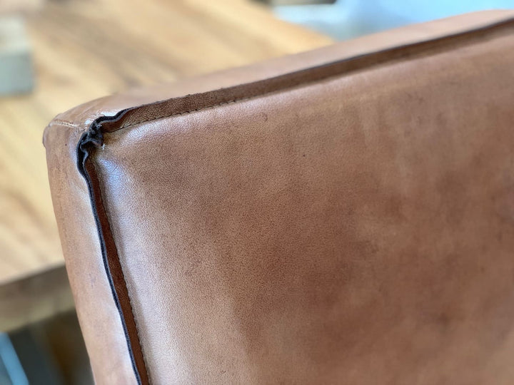 Barstuhl Leder Industrial Detailaufnahme: Nahaufnahme der braunen Leder-Rückenlehne mit sichtbarer Kedernaht und feiner Struktur, die die hochwertige Verarbeitung im Industrial-Stil hervorhebt.