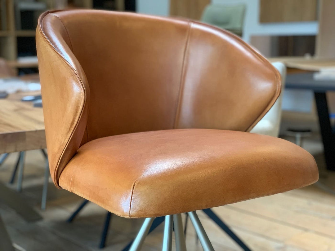 Design Barhocker Leder in Detailansicht der Sitzschale, hochwertiger Lederbezug in Cognac mit weicher Polsterung, ergonomisch geformte Rückenlehne und Armauflage für hohen Sitzkomfort, modernes Design für stilvolle Wohn- und Barbereiche.