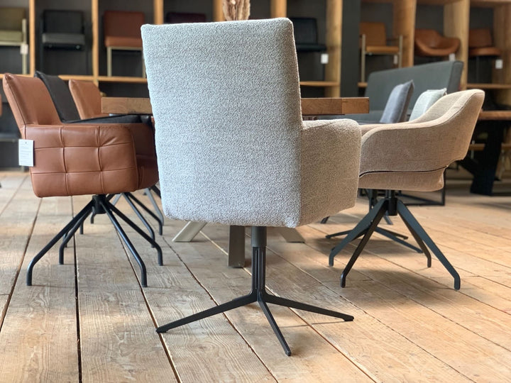 Design Esszimmerstuhl drehbar Stoff in moderner Rückansicht mit hellem Strukturbezug, hoher Rückenlehne und elegantem Metallgestell, stilvoll platziert an einem Holztisch im Essbereich.