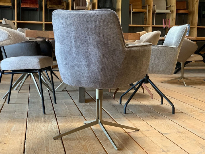 Designer Esszimmer-Drehstuhl in Rückansicht, grauer Stoffbezug mit Armlehnen und drehbares Metallgestell in stilvoller Wohnumgebung.