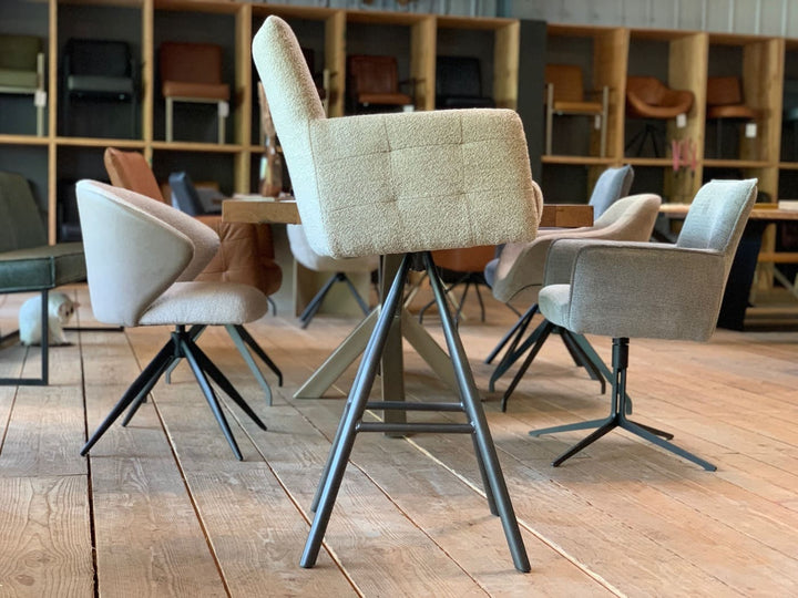 Drehbarer Barhocker mit Stoffbezug in Seitenansicht, gepolsterte Rückenlehne und Sitzfläche, modernes Design mit stabilem Metallgestell und mehreren Standfüßen, ideal für stilvolle Ess- und Barbereiche.