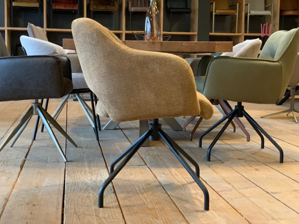 Drehbarer Esszimmerstuhl mit Stoffbezug in Seitenansicht – ergonomisch geformte Sitzschale, angenehme Polsterung und stabiles Metallgestell in Schwarz für modernen Wohnkomfort.