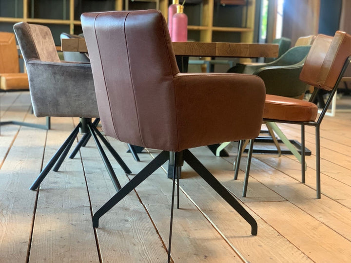 Rückansicht eines drehbaren Drehstuhls aus Echtleder mit glatter Rückenlehne, umlaufender Polsterung und stabilem Metallgestell in modernem Esszimmer.