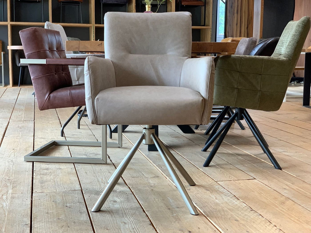 Vorderansicht eines modernen Drehstuhl Leder hohe Rückenlehne in hochwertigem Leder in der Farbe Taupe, mit gepolsterter Sitzfläche und Armlehnen auf einem stabilen Metall-Drehgestell, platziert an einem Holztisch in einem stilvollen Essbereich.