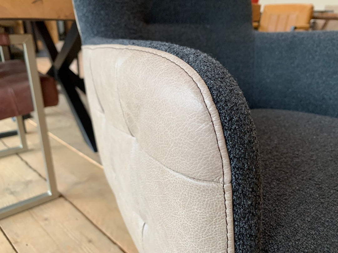 Esszimmer Drehstuhl Leder Stoff: Detailansicht des Materialübergangs zwischen strukturiertem Stoff und hochwertigem Leder an der gepolsterten Armlehne, modern verarbeitet für stilvolle Esszimmermöbel.