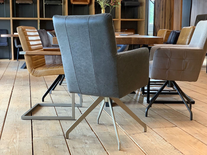 Esszimmer Drehstuhl HR159DF aus grauem Leder mit hoher Rückenlehne in Rückansicht, an einem Holztisch in moderner Wohnumgebung mit weiteren gepolsterten Stühlen auf hellem Holzboden.