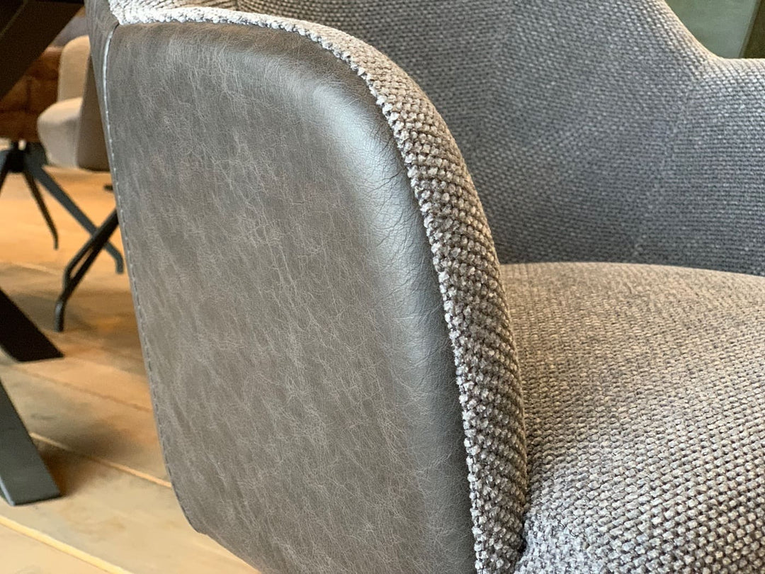 Esszimmer Drehstuhl Stoff Leder Kombination Detailaufnahme mit sichtbarem Übergang zwischen grauem Stoffbezug und glatter Lederoberfläche, hochwertige Materialkombination in moderner Optik