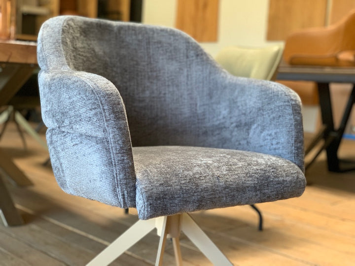 Detailaufnahme der gepolsterten Sitzschale eines Esszimmer-Drehstuhls mit Stoffbezug – weiche Oberfläche, ergonomische Form und angenehm geschwungene Armlehnen für maximalen Sitzkomfort.