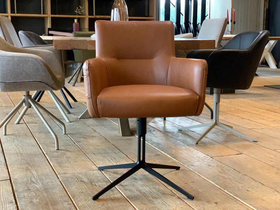 Esszimmer Lederstuhl drehbar aus hochwertigem braunem Leder mit gepolsterter Sitzfläche, Armlehnen und schwarzem Sternfuß in einem modernen Esszimmer.