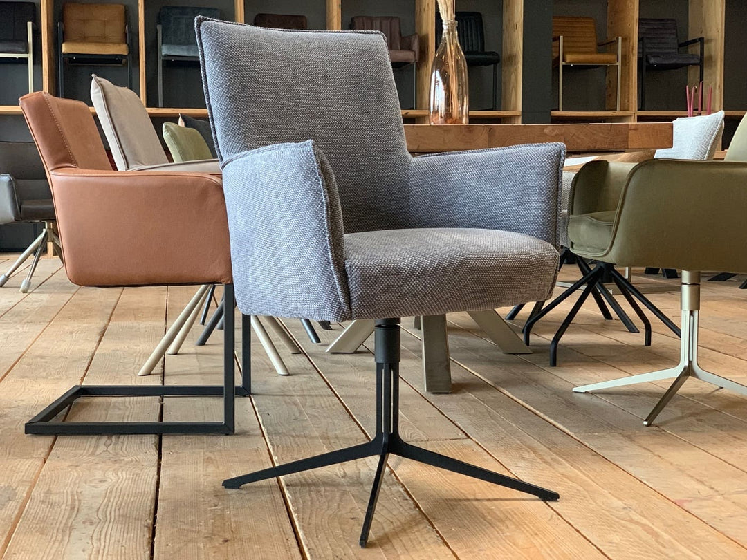 Esszimmerstühle Drehstühle in modernem Design mit gepolsterten Sitzflächen und Armlehnen, kombiniert mit stabilen Metallgestellen, arrangiert an einem Holztisch in stilvollem Essbereich.