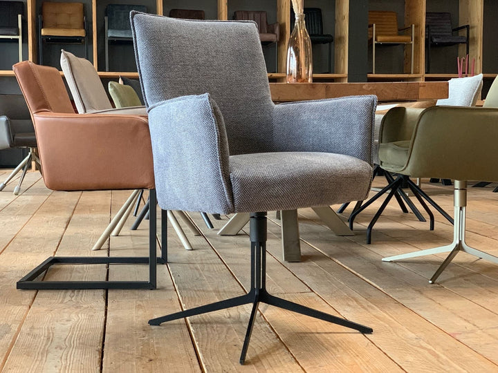 Esszimmerstühle Drehstühle in modernem Design mit gepolsterten Sitzflächen und Armlehnen, kombiniert mit stabilen Metallgestellen, arrangiert an einem Holztisch in stilvollem Essbereich.