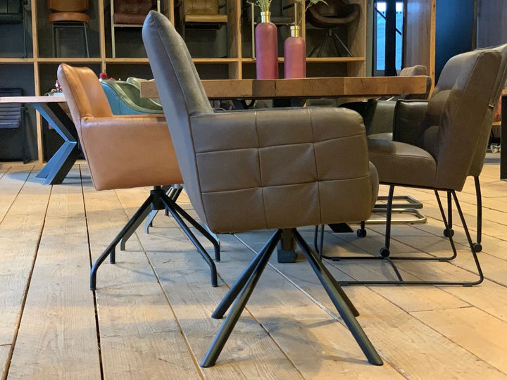 Esszimmerstuhl Drehstuhl: Seitenansicht eines modernen Drehstuhls mit gepolstertem Sitz in Lederoptik und stabiler Metall-Drehbasis, kombiniert mit stilvollen Esszimmerstühlen an einem Holztisch im wohnlichen Ambiente.