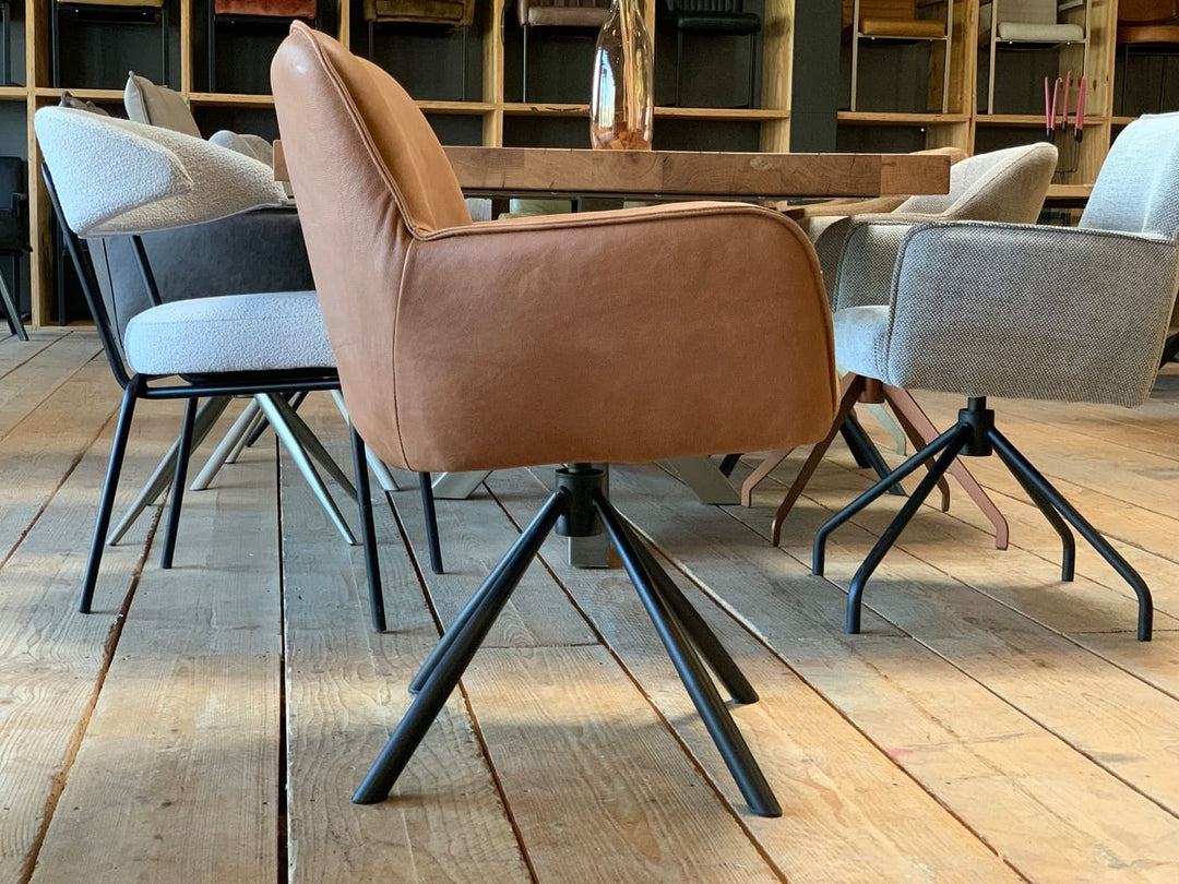 Esszimmerstuhl drehbar Leder Cognac Seitenansicht mit Armlehnen und schwarzem Metallgestell im modernen Design
