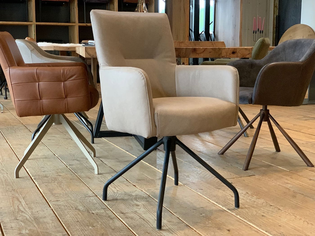 Esszimmerstuhl drehbar aus Leder in Taupe mit Armlehnen, an einem Holztisch in moderner Wohnumgebung mit weiteren gepolsterten Stühlen auf hellem Holzboden.