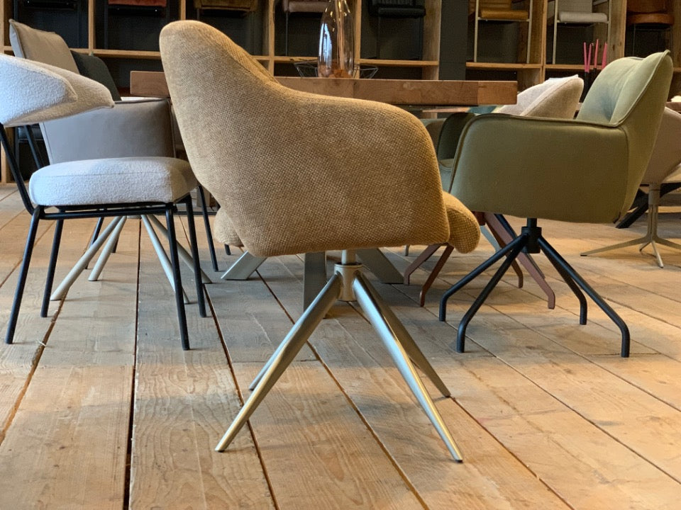 Moderner Esszimmerstuhl mit Drehfunktion und hochwertigem Stoffbezug in warmem Beige. Die komfortabel gepolsterte Sitzschale mit integrierten Armlehnen sorgt für angenehmes Sitzen, während das elegante Metallgestell in hellem Finish dem Stuhl eine stilvolle, zeitgemäße Optik verleiht – ideal für ein modernes Esszimmer.