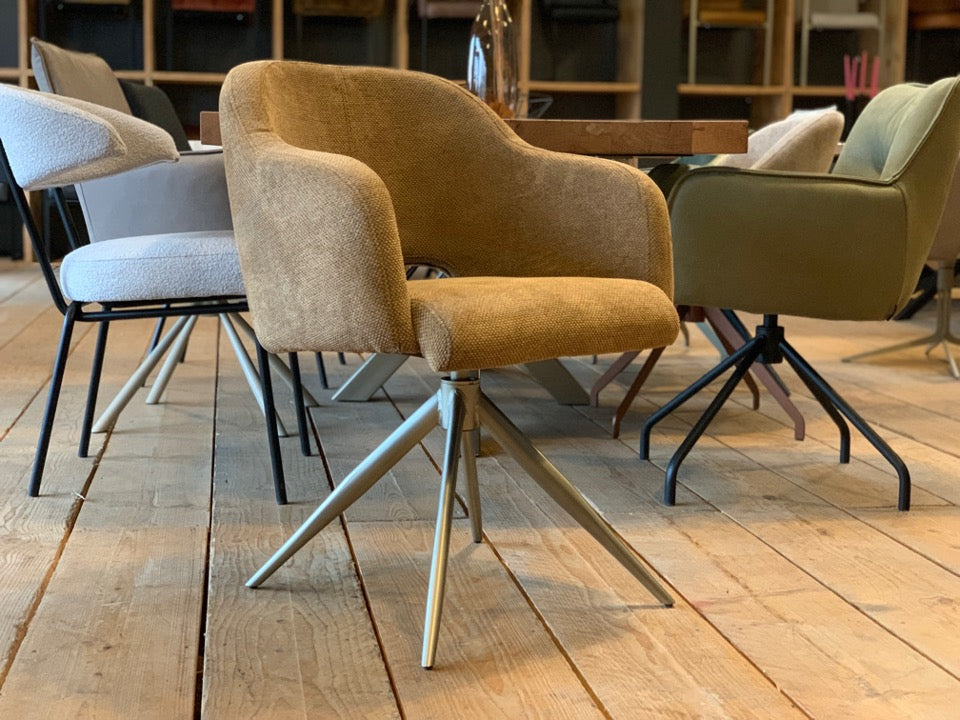 Moderner Esszimmerstuhl mit Drehfunktion und hochwertigem Stoffbezug in warmem Beige. Die komfortabel gepolsterte Sitzschale mit integrierten Armlehnen sorgt für angenehmes Sitzen, während das elegante Metallgestell in hellem Finish dem Stuhl eine stilvolle, zeitgemäße Optik verleiht – ideal für ein modernes Esszimmer.
