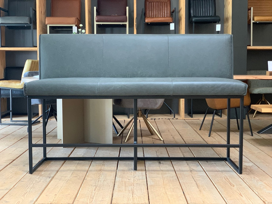 Hochbank aus Leder mit dunkelgrauem Bezug und gerader Rückenlehne, kombiniert mit schwarzem Metallgestell im Industrial-Stil, in moderner Esszimmerumgebung.