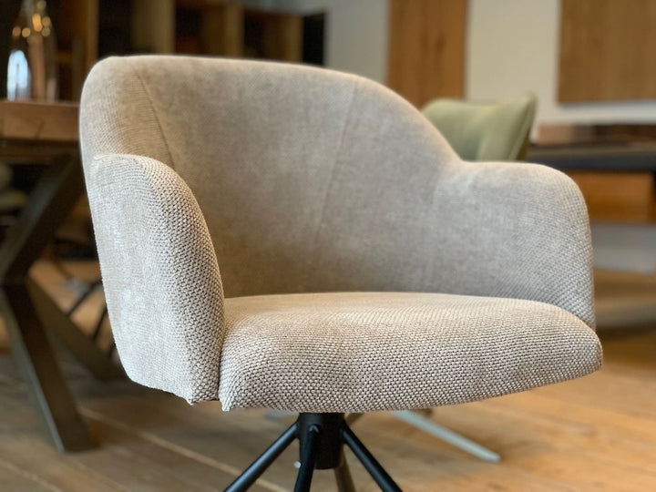 Detailaufnahme der Sitzschale eines hochwertigen, drehbaren Armlehnenstuhls mit ergonomisch geschwungener Form, bezogen mit fein strukturiertem Stoff in elegantem Beigeton – für maximalen Sitzkomfort und modernes Design im Essbereich.