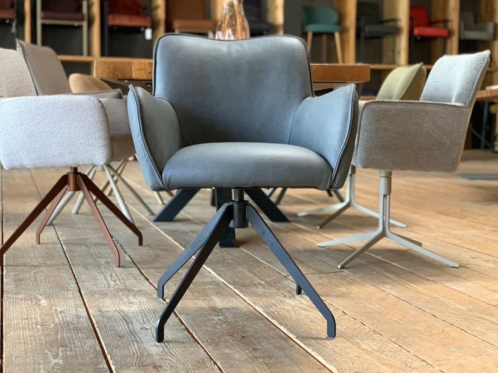 Vorderansicht eines hochwertigen Drehstuhls aus Leder in modernem Design, mit komfortablen Armlehnen und stabilem Metallgestell, stilvoll präsentiert im Showroom.