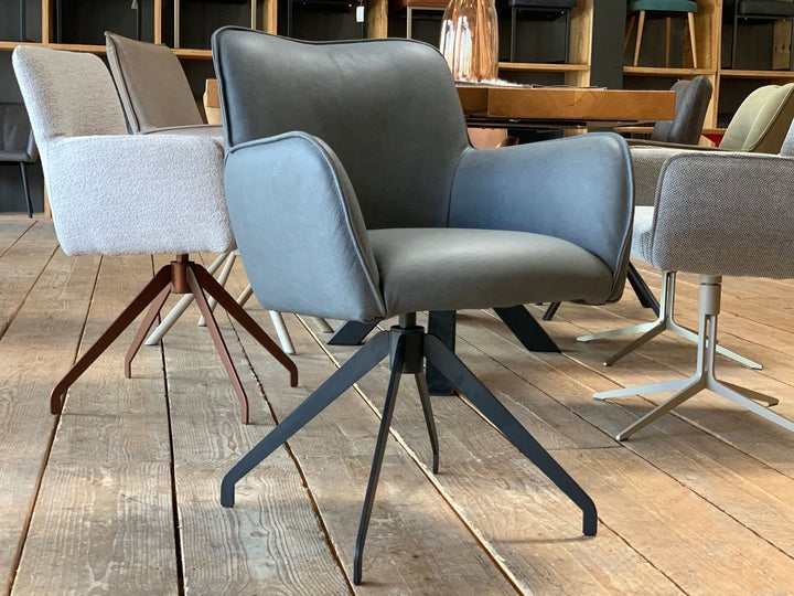 Hochwertiger Drehstuhl aus Leder in modernem Design, mit Armlehnen und stabilem Metallgestell – stilvoll präsentiert in einem eleganten Showroom.
