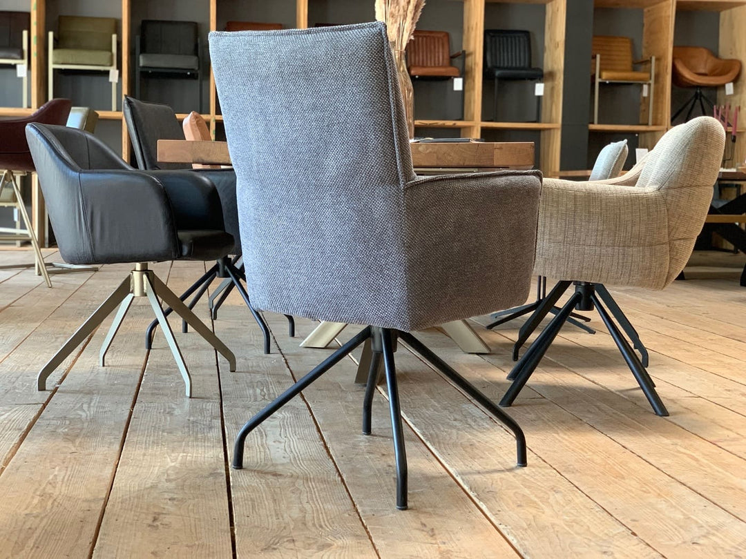 Hochwertiger Esszimmerstuhl drehbar Stoff in moderner Rückansicht mit grauem Bezug, ergonomischer Rückenlehne und stabilem Metallgestell, arrangiert an einem Holztisch in stilvollem Essbereich.