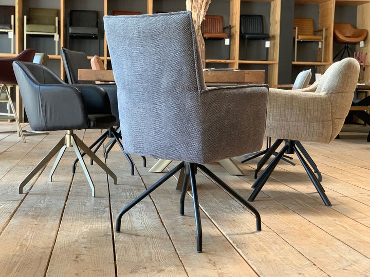 Hochwertiger Esszimmerstuhl drehbar Stoff in moderner Rückansicht mit grauem Bezug, ergonomischer Rückenlehne und stabilem Metallgestell, arrangiert an einem Holztisch in stilvollem Essbereich.