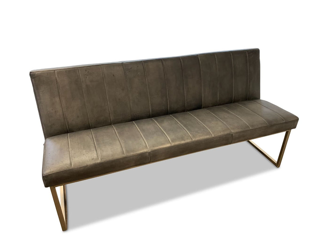Moderne Lederbank als Polsterbank in braun-grauem Leder mit vertikaler Steppung, leicht geneigter Rückenlehne und filigranem Metallgestell im Industrial-Stil.