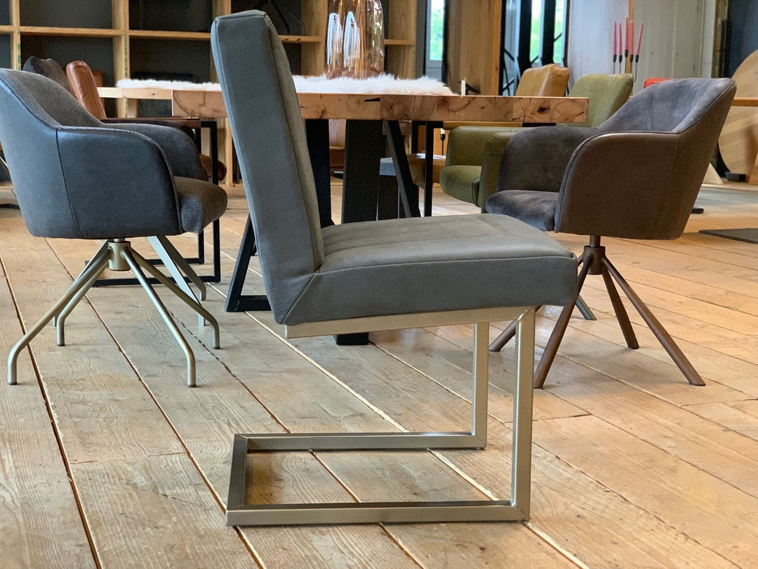 Seitenansicht eines Lederstuhls ohne Armlehnen in der Lederfarbe Botswana Grey und einem Untergestell in der Farbe silber
