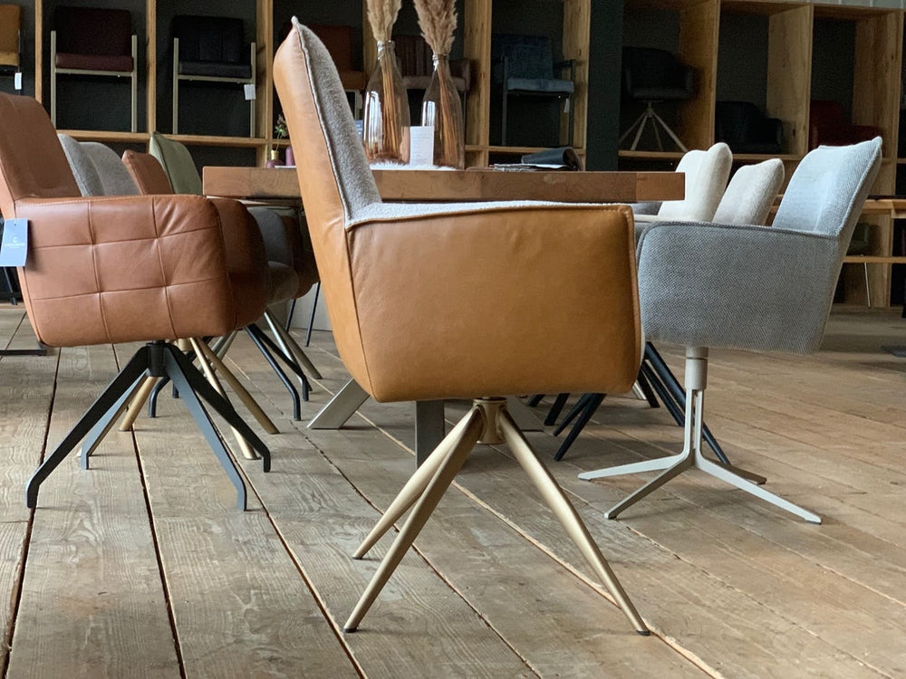 Moderner Design Esszimmerstuhl drehbar in Seitenansicht, hohe Rückenlehne mit Stoffbezug und Lederaußenseite, stabiles Metallgestell im eleganten Stil
