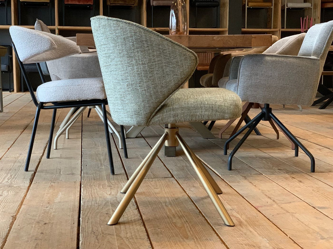 Moderner Esszimmer Drehstuhl – Seitenansicht eines stilvollen drehbaren Esszimmerstuhls mit gepolsterter Stoff-Sitzschale und elegantem Metallgestell