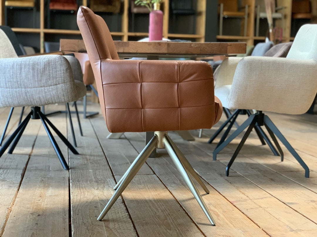 Seitenansicht des modernen, drehbaren Lederstuhls Modell 119T mit ergonomisch geformter Rückenlehne und gepolsterter Sitzfläche. Besonders hervorgehoben ist die abgesetzte Karo-Besteppung, die dem hochwertigen Lederbezug eine markante, stilvolle Struktur verleiht. Das stabile Metallgestell und die klare Linienführung betonen das elegante, zeitgemäße Design.