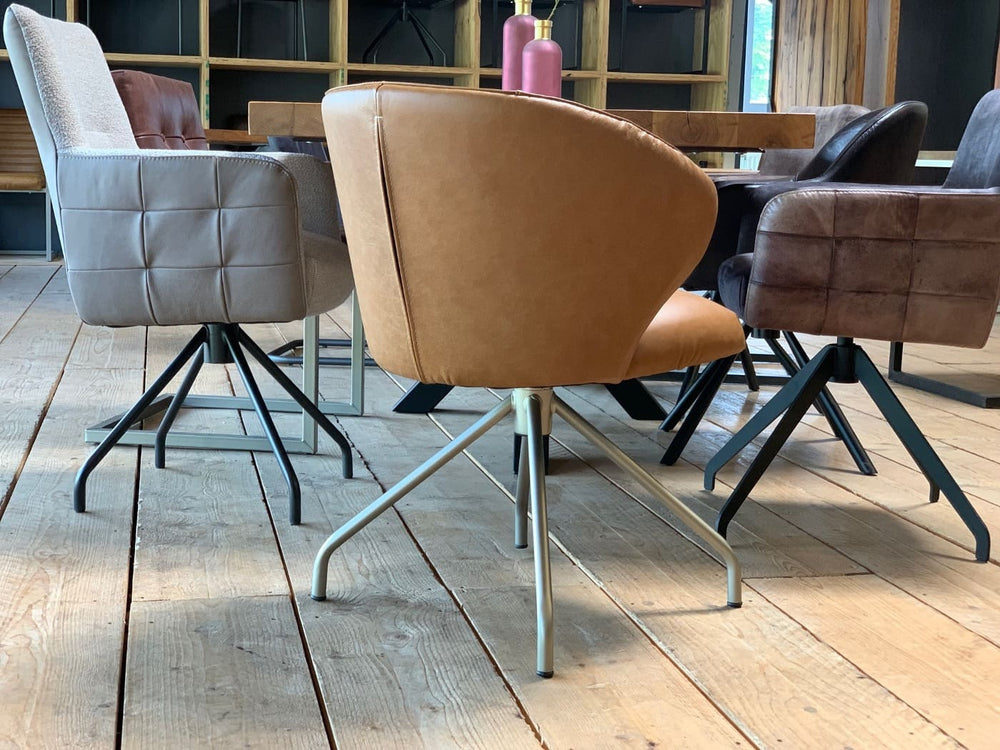Rückansicht eines modernen drehbaren Lederstuhls mit elegant geformter Sitzschale, hochwertigem Lederbezug und filigranem Metallgestell im stilvollen Essbereich.