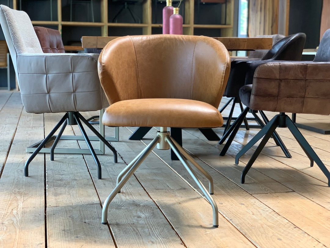 Moderner drehbarer Lederstuhl in Vorderansicht mit ergonomischer Sitzschale, hochwertigem Bezug und stabilem Metallgestell im stilvollen Essbereich.