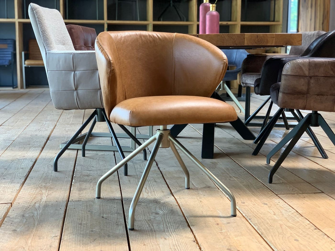 Moderner drehbarer Lederstuhl mit ergonomisch geformter Sitzschale, hochwertigem Lederbezug und filigranem Metallgestell in stilvollem Esszimmer.