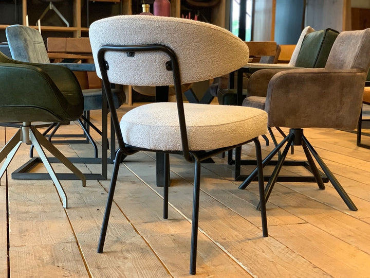 Moderner Küchen- und Gastrostuhl mit gepolsterter Sitz- und Rückenfläche in hellem Stoff und schwarzem Metallgestell, Rückansicht im stilvollen Essbereich