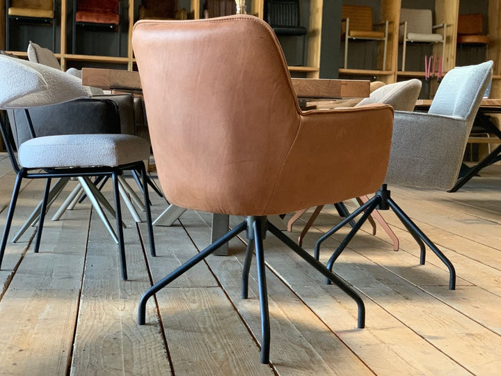 Rückansicht eines modernen Polsterstuhls aus hochwertigem Leder in warmem Cognac-Ton, mit drehbarem Gestell und elegant geschwungener Rückenlehne – stilvolles Design für anspruchsvolle Wohn- und Arbeitsbereiche.