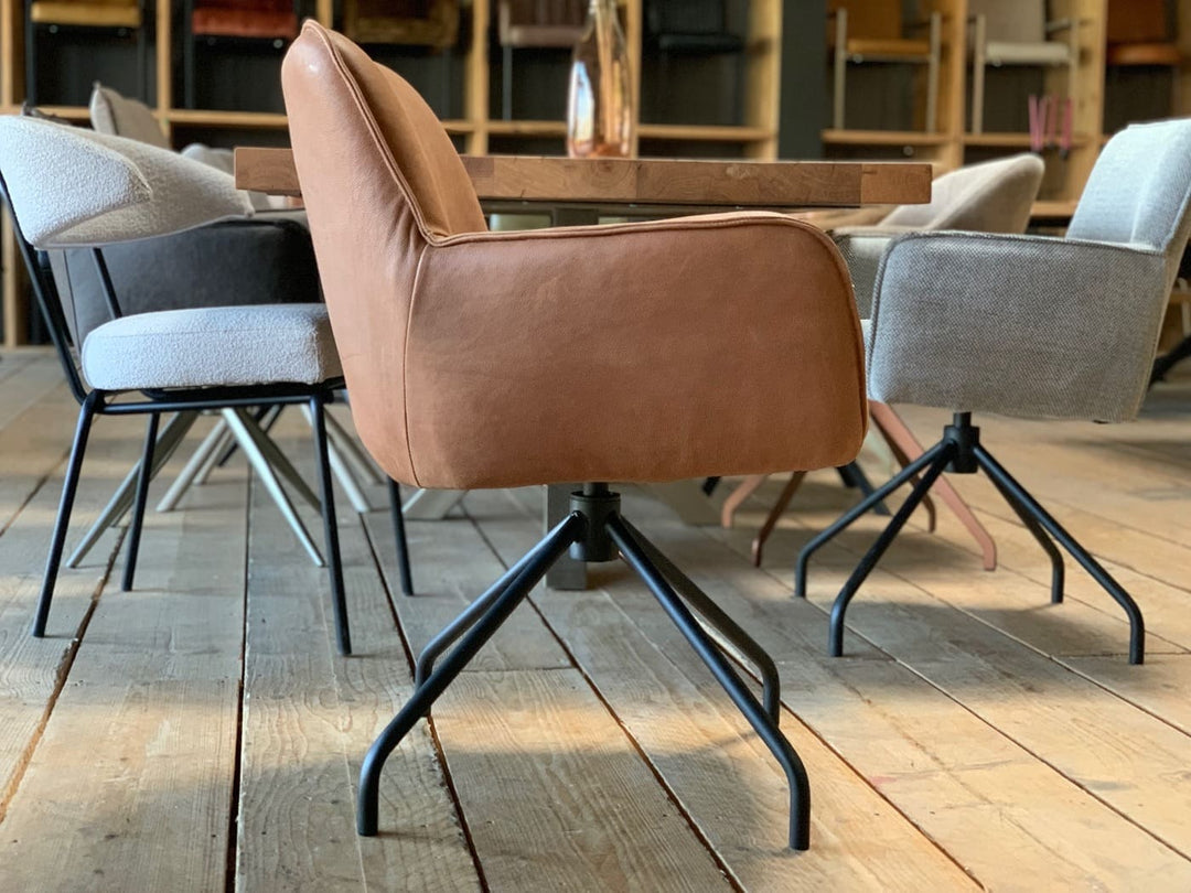 Seitenansicht eines modernen Polsterstuhls aus hochwertigem Leder in elegantem Cognac, mit drehbarem Gestell und klarer Linienführung – ideal für stilvolle Ess- oder Arbeitsbereiche.
