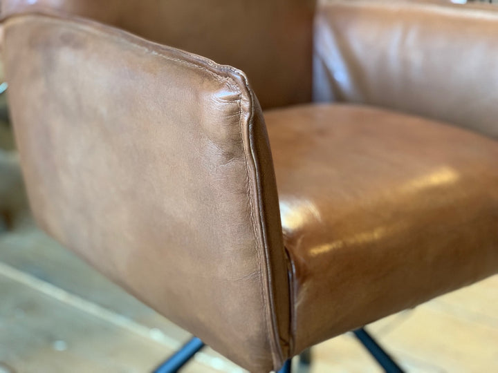 Detailaufnahme eines drehbaren Polsterstuhls aus hochwertigem Leder in Braun, mit feiner Nahtführung und edler Oberfläche – stilvoll präsentiert im Showroom in Hamburg.