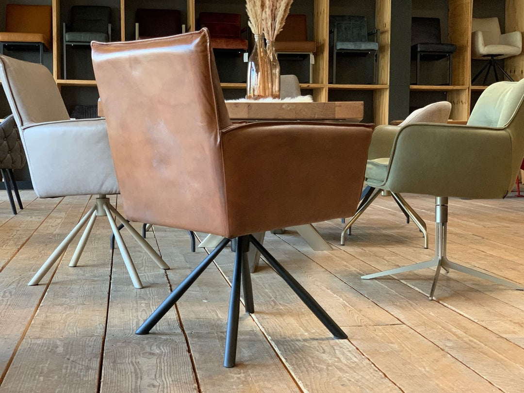 Rückansicht eines drehbaren Polsterstuhls aus Leder in edlem Braun, kombiniert mit modernem Metallfuß und stilvoller Präsentation im Showroom in Hamburg.