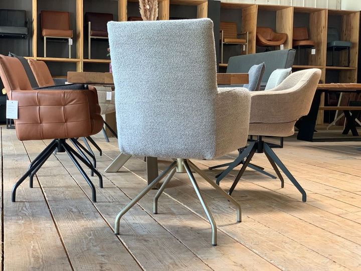 Polsterstuhl mit hoher Rückenlehne in Rückansicht, bezogen mit hochwertigem, strukturiertem Stoff in hellgrauer Optik, kombiniert mit einem stabilen, drehbaren Metallgestell – ideal für moderne Esszimmer mit stilvollem Anspruch.