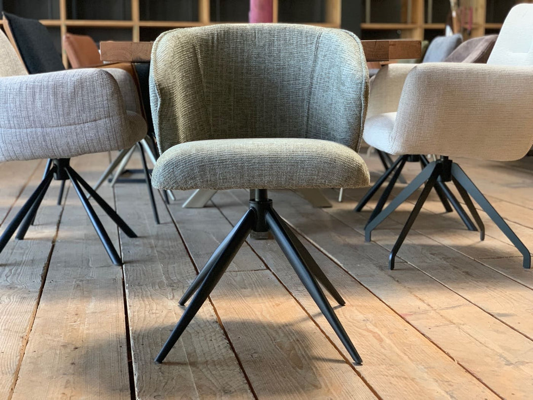 Schalenstuhl Esszimmer Stoff drehbar – Vorderansicht eines modernen Esszimmerstuhls mit gepolsterter Stoff-Sitzschale und schwarzem drehbarem Metallgestell