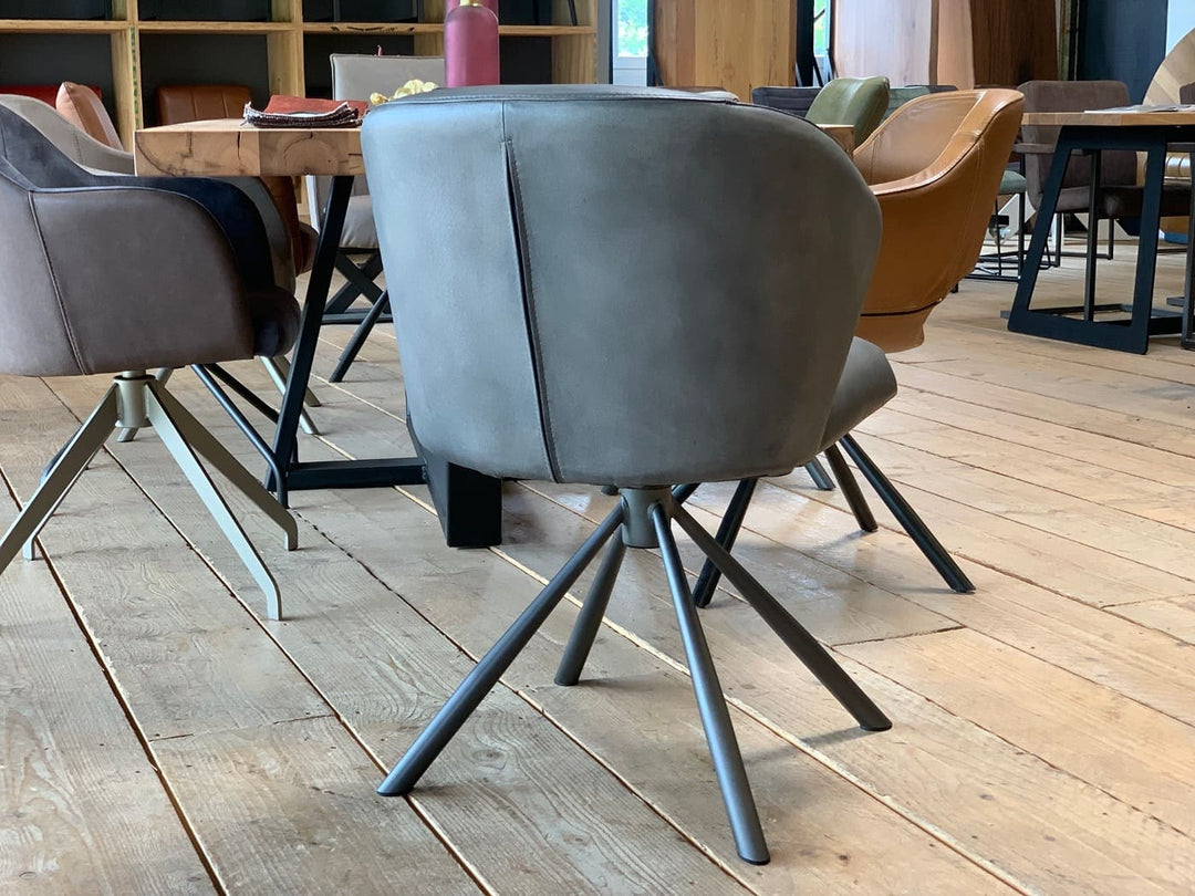 Drehbarer Schalenstuhl aus Leder in Rückansicht mit glatter Rückenfläche, feiner Nahtführung und stabilem Metallgestell im modernen Esszimmer.