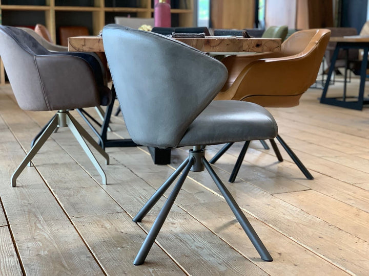 Drehbarer Schalenstuhl aus Leder in Seitenansicht mit ergonomisch geformter Sitzschale, gepolsterter Sitzfläche und modernem Metallgestell im Esszimmer.
